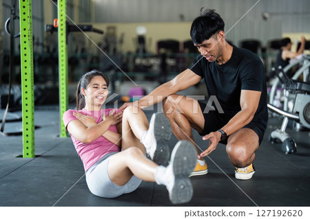 Workout and Fitness. Young couple doing core exercises in gym for strength. 127192620