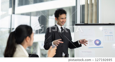 Business Presentation and Team Collaboration. Professional man presenting data insights in a modern office. Business Presentation and Team Collaboration. Professional man presenting data insights in a modern office. 127192695