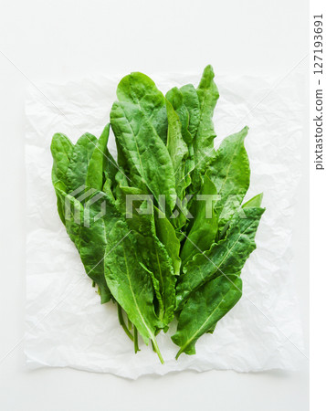 Pile of fresh green spinach sorrel leaves on the wooden table background, top view bunch of greens on the table with water drops. 127193691
