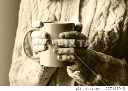 Hands with a cup of hot tea Hands with a cup of hot tea 127193943