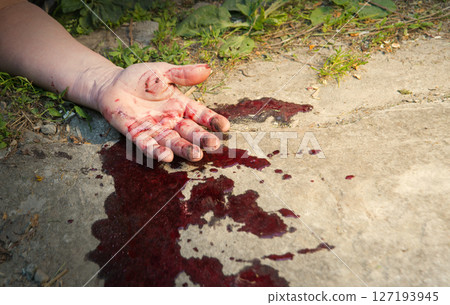 A man's hand in blood lies on the ground A man's hand in blood lies on the ground 127193945