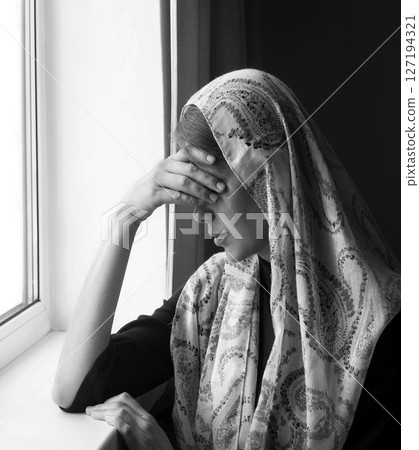 Woman thinking at the window 127194321