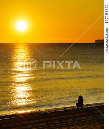 Person silhouette on beach enjoy sunrise Person silhouette on beach enjoy sunrise 127195551