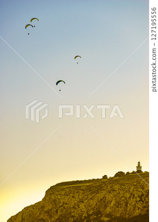 Paragliders flying in sky. Paragliders flying in sky. 127195556