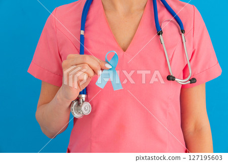 Doctor hands holding blue ribbon, diabetes and Colorectal Cancer Awareness 127195603