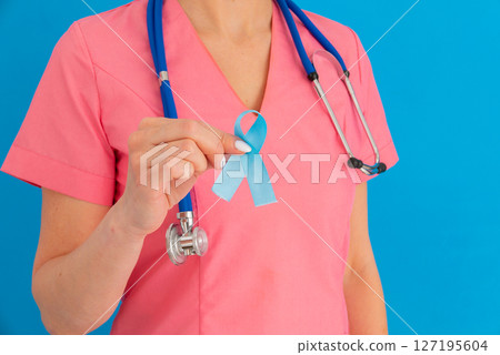 Doctor hands holding blue ribbon, diabetes and Colorectal Cancer Awareness 127195604