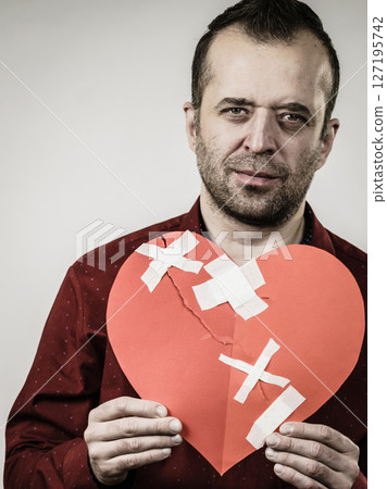 Adult man holding broken heart 127195742