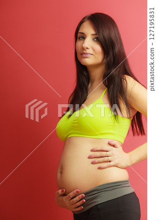 Long hair pregnant woman on red Long hair pregnant woman on red 127195831