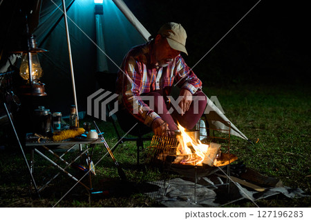 Solo camper eating ramen for midnight snack Solo camp Senior 127196283