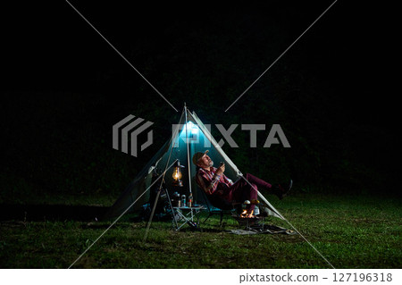 Solo camper drinking alcohol while looking up at the night sky Solo camp Senior Solo camper drinking alcohol while looking up at the night sky Solo camp Senior 127196318