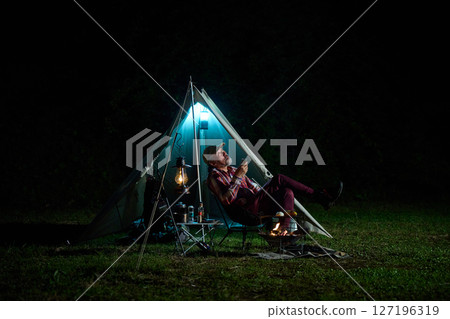 Solo camper drinking alcohol while looking up at the night sky Solo camp Senior Solo camper drinking alcohol while looking up at the night sky Solo camp Senior 127196319