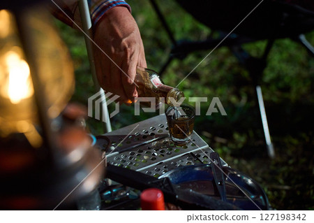 Solo camper drinking alcohol, solo camping, senior Solo camper drinking alcohol, solo camping, senior 127198342