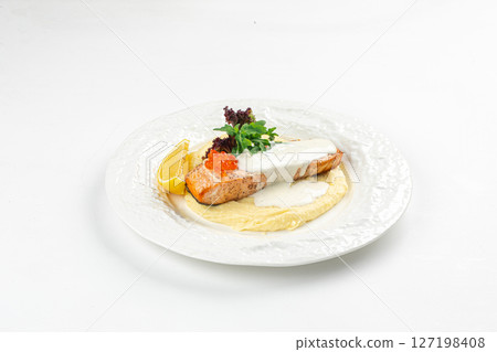 Portion of salmon fillet steak with creamy sauce 127198408