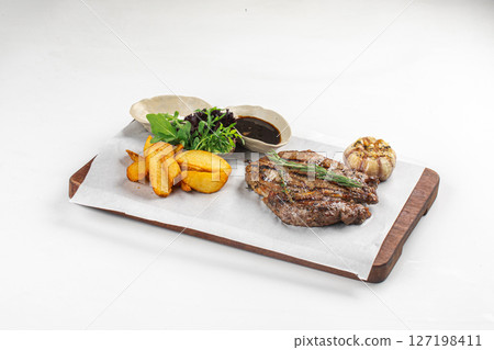 Portion of grilled beef steak with potato and sauce Portion of grilled beef steak with potato and sauce 127198411