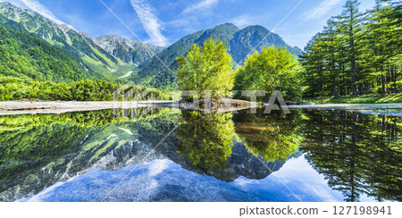 Panoramic view of the vast nature of Kamikochi in summer: Mt. Hotaka's fresh greenery reflected in the Azusa River [Matsumoto City, Nagano Prefecture] 127198941
