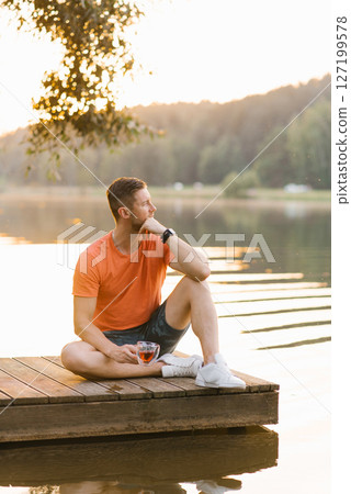 Relaxing Man Sitting On Wooden Pier 127199578