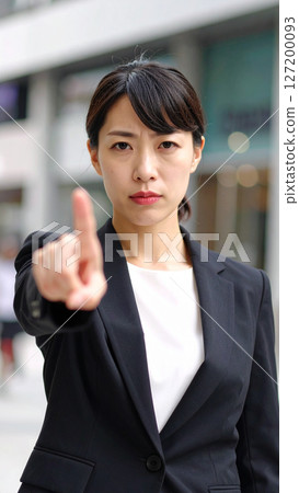 Angry businesswoman pointing her finger (AI-generated image) 127200093