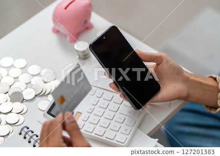 Financial Transactions. Individual holding a credit card and smartphone for payments. Financial Transactions. Individual holding a credit card and smartphone for payments. 127201383
