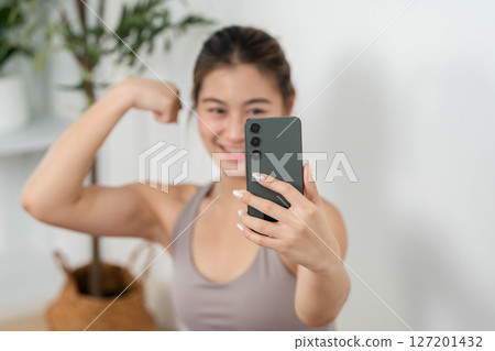 Yoga and Fitness. Young woman taking a selfie after workout, showcasing strength and positivity. Yoga and Fitness. Young woman taking a selfie after workout, showcasing strength and positivity. 127201432