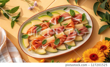Sliced melon and prosciutto with mint leaves on ceramic plate, summer vibes. Sliced melon and prosciutto with mint leaves on ceramic plate, summer vibes. 127201525