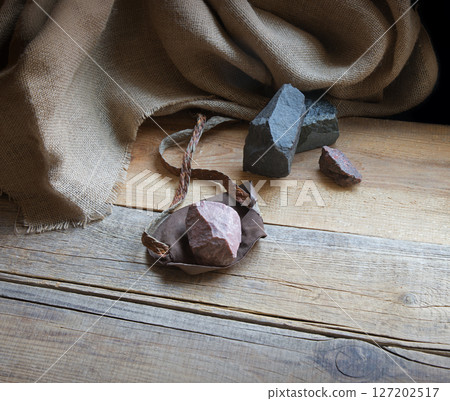 An antique leather sling lies on wooden desk An antique leather sling lies on wooden desk 127202517
