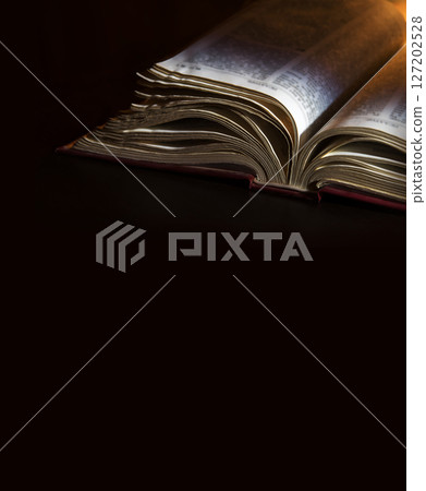 Dark table with open bible 127202528