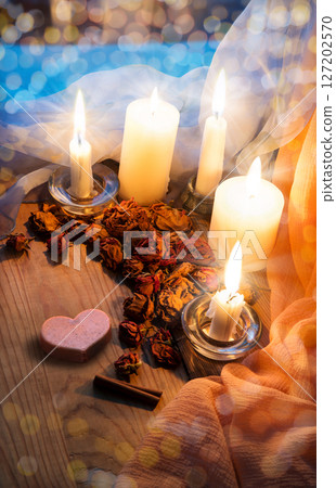 Candles and dried rosebuds on the table Candles and dried rosebuds on the table 127202570