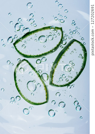 Three aloe vera slices floating in clear water surrounded by air bubbles, representing freshness, hydration, and natural skincare Three aloe vera slices floating in clear water surrounded by air bubbles, representing freshness, hydration, and natural skincare 127202691
