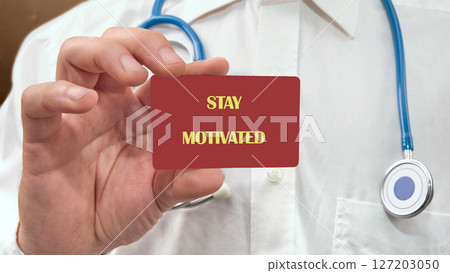 Business, support, motivation, psychological concept. STAY MOTIVATED on the card in the hands of a man in white clothes 127203050