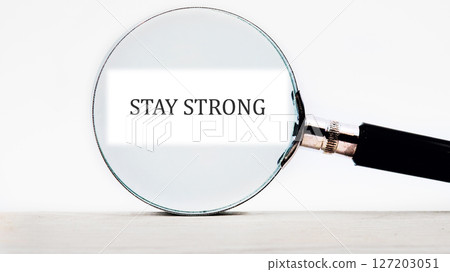 STAY STRONG message focused through a magnifying glass 127203051
