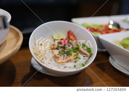 ingredients for vietnamese pho bo soup. bowl with chopsticks, spoon. Space for text. Top view. Asian soup Pho bo on wooden table background. Vietnamese soup ingredients for vietnamese pho bo soup. bowl with chopsticks, spoon. Space for text. Top view. Asian soup Pho bo on wooden table background. Vietnamese soup 127203809
