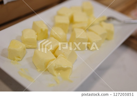 Pieces of fresh butter on white textured table, closeup. Space for text Pieces of fresh butter on white textured table, closeup. Space for text 127203851