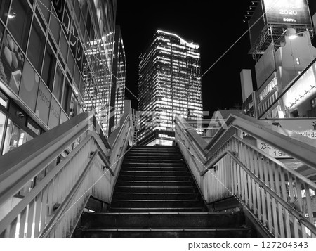Skyscrapers and pedestrian bridge stairs in front of Shibuya Station. Monochrome. 127204343