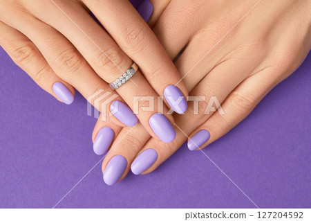 Womans hands with fashionable purple manicure. Spring summer nail design 127204592