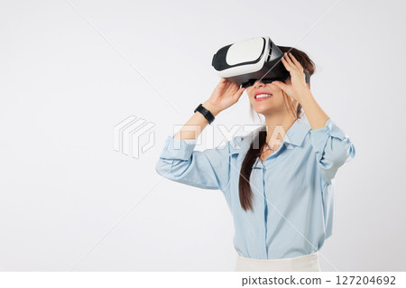 Young asian woman using vr headset for future game tech, teenage experience with virtual reality, much gesticulating hands and exploring cyberspace in vr, isolated studio white background Young asian woman using vr headset for future game tech, teenage experience with virtual reality, much gesticulating hands and exploring cyberspace in vr, isolated studio white background 127204692
