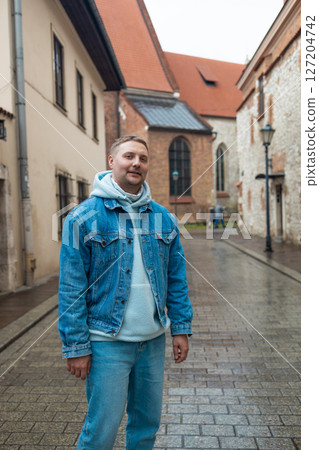 Man Smiling on a Rainy Day in Old European Street 127204742