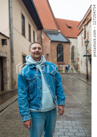 Man Smiling on a Rainy Day in Old European Street 127204754