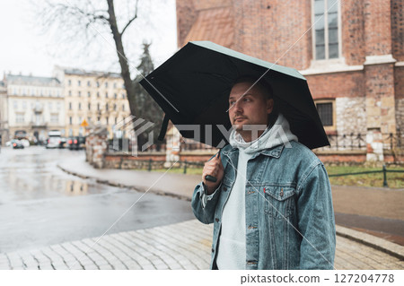 Man Walking with Umbrella on a Rainy Day 127204778