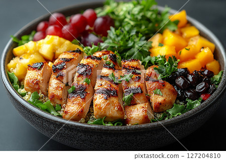 Packed office lunch box with quinoa salad, grilled chicken, mixed greens and fruit. 127204810