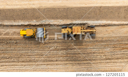 Aerial view motor grader civil at construction site, Motor grader work on construction site, Road grader on road construction site machine work on the construction of new road. 127205115