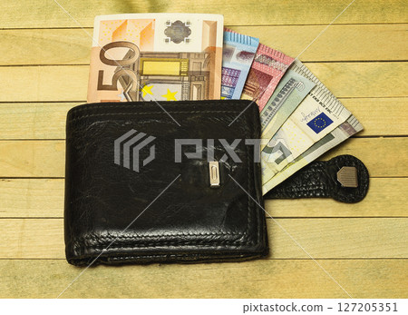 Leather purse lying on a wooden surface Leather purse lying on a wooden surface 127205351