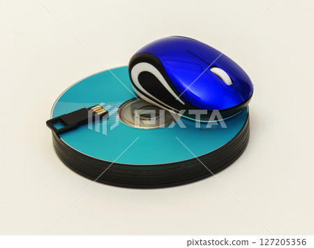 Computer mouse and USB flash lie on a stack of CD / DVD disk Computer mouse and USB flash lie on a stack of CD / DVD disk 127205356
