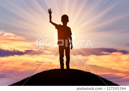 Disabled Boy with Prosthetic Arm Waving, Sunset Silhouette Disabled Boy with Prosthetic Arm Waving, Sunset Silhouette 127205594