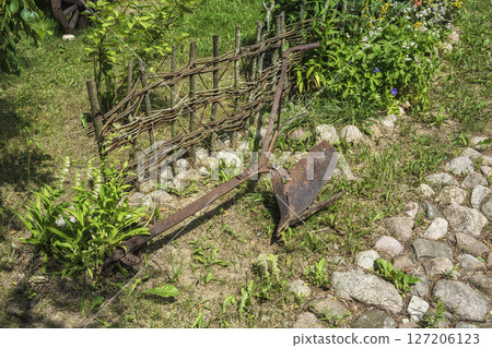 Old rusty plow for plowing the ground lying on the grass Old rusty plow for plowing the ground lying on the grass 127206123