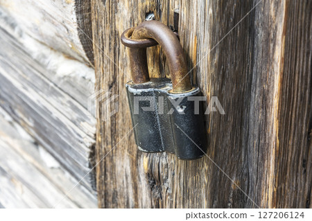 Wooden door closed on the old padlock, close-up, side view Wooden door closed on the old padlock, close-up, side view 127206124
