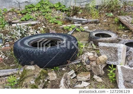 Environment and ecology. Car tires and construction debris dumped on the ground 127206129