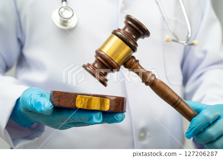 Doctor holding judge gavel, forensic medicine, medical law and crime justice. 127206287
