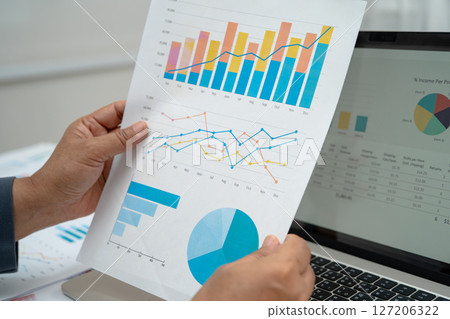Asian business woman working with financial graph. 127206322