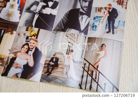 Printed wedding photos laid out on a wooden surface. Printed wedding photos laid out on a wooden surface. 127206719