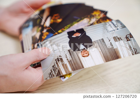 hands Printed wedding photos laid out on a wooden surface. hands Printed wedding photos laid out on a wooden surface. 127206720